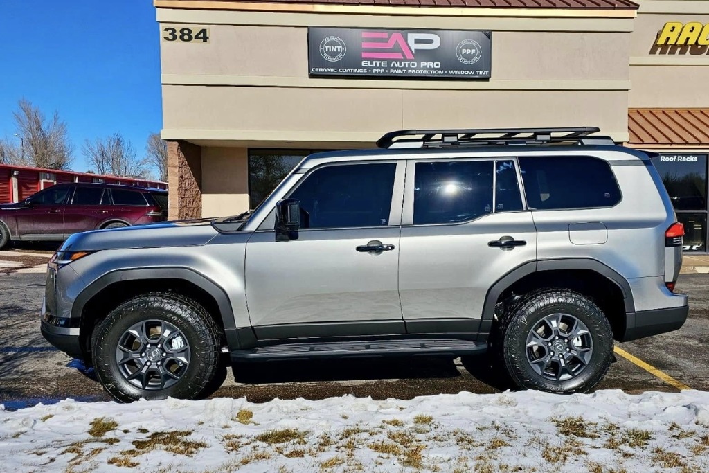 A silver SUV parked outside Elite Auto Pro in Colorado Springs, with snow on the ground and clear skies overhead, highlighting the vehicle's exposure to intense UV rays at high altitude. The vehicle's pristine appearance emphasizes the protective benefits of high-quality PPF against sun damage.